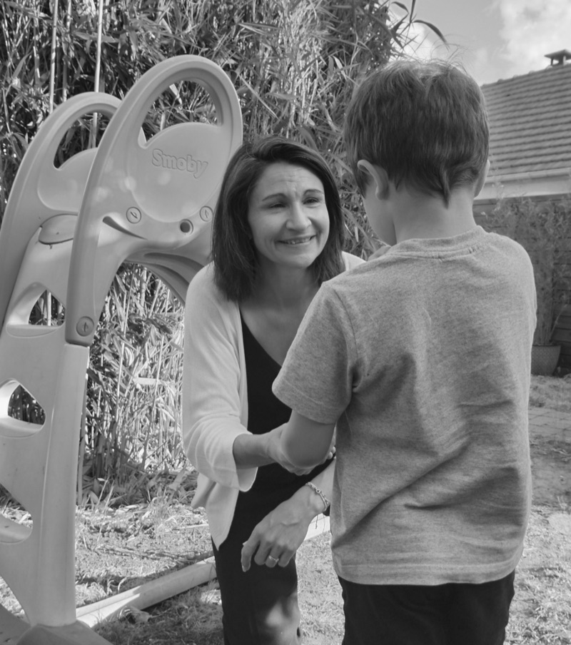 Sophie Rocca, éducatrice de jeunes enfants, échangeant avec un enfant dans un jardin